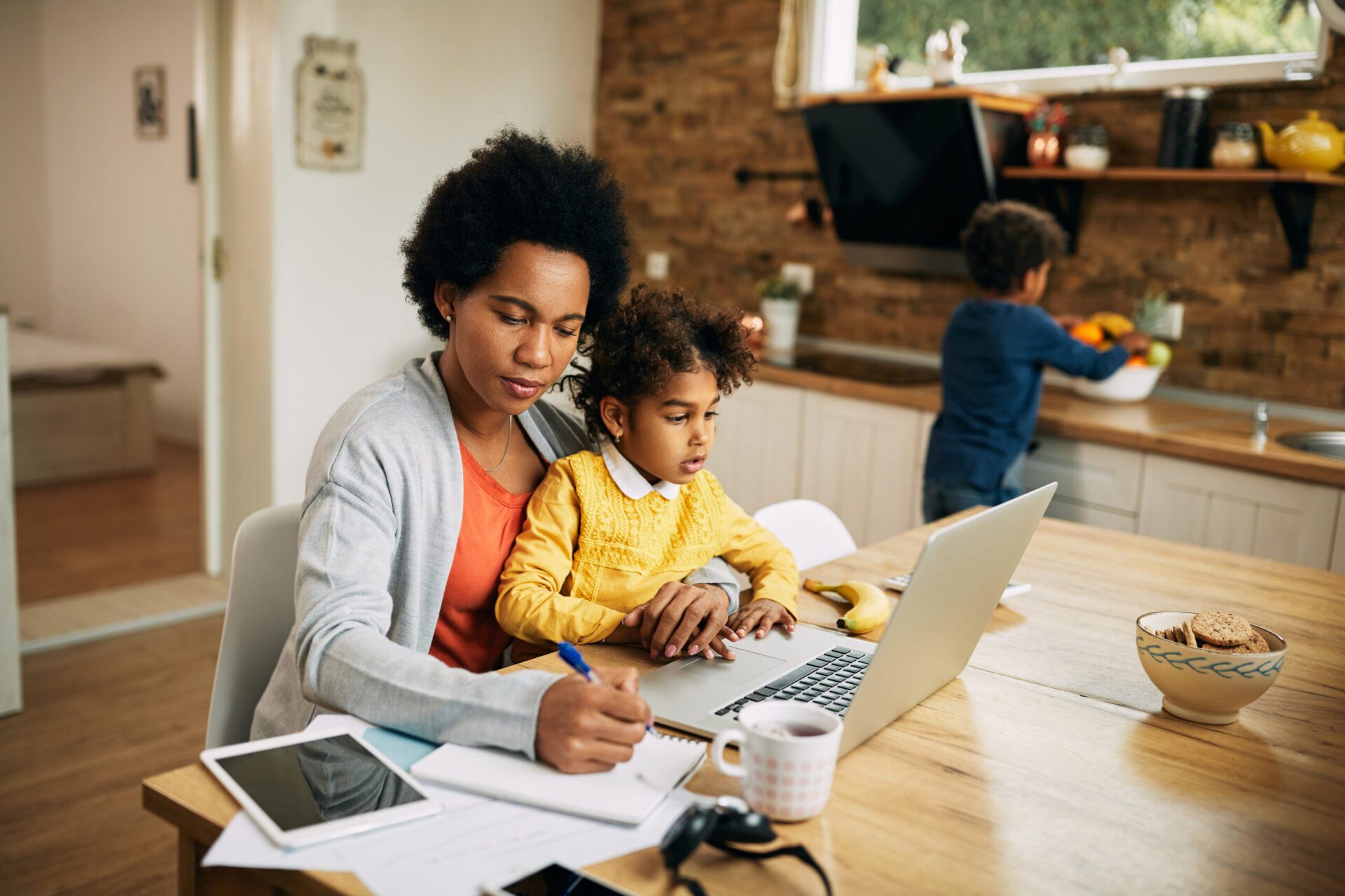 African American single mother with two kids working at home