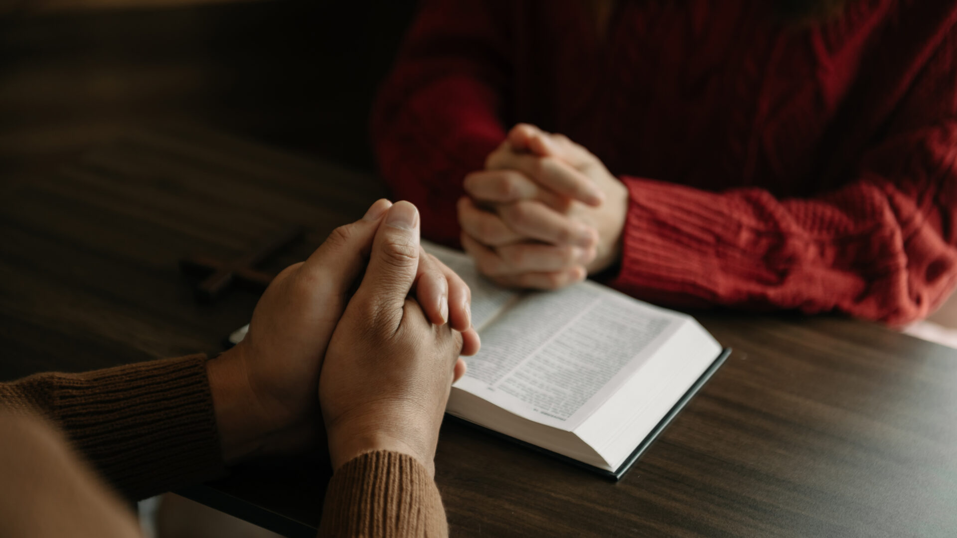Two people reading and study bible in home and pray together
